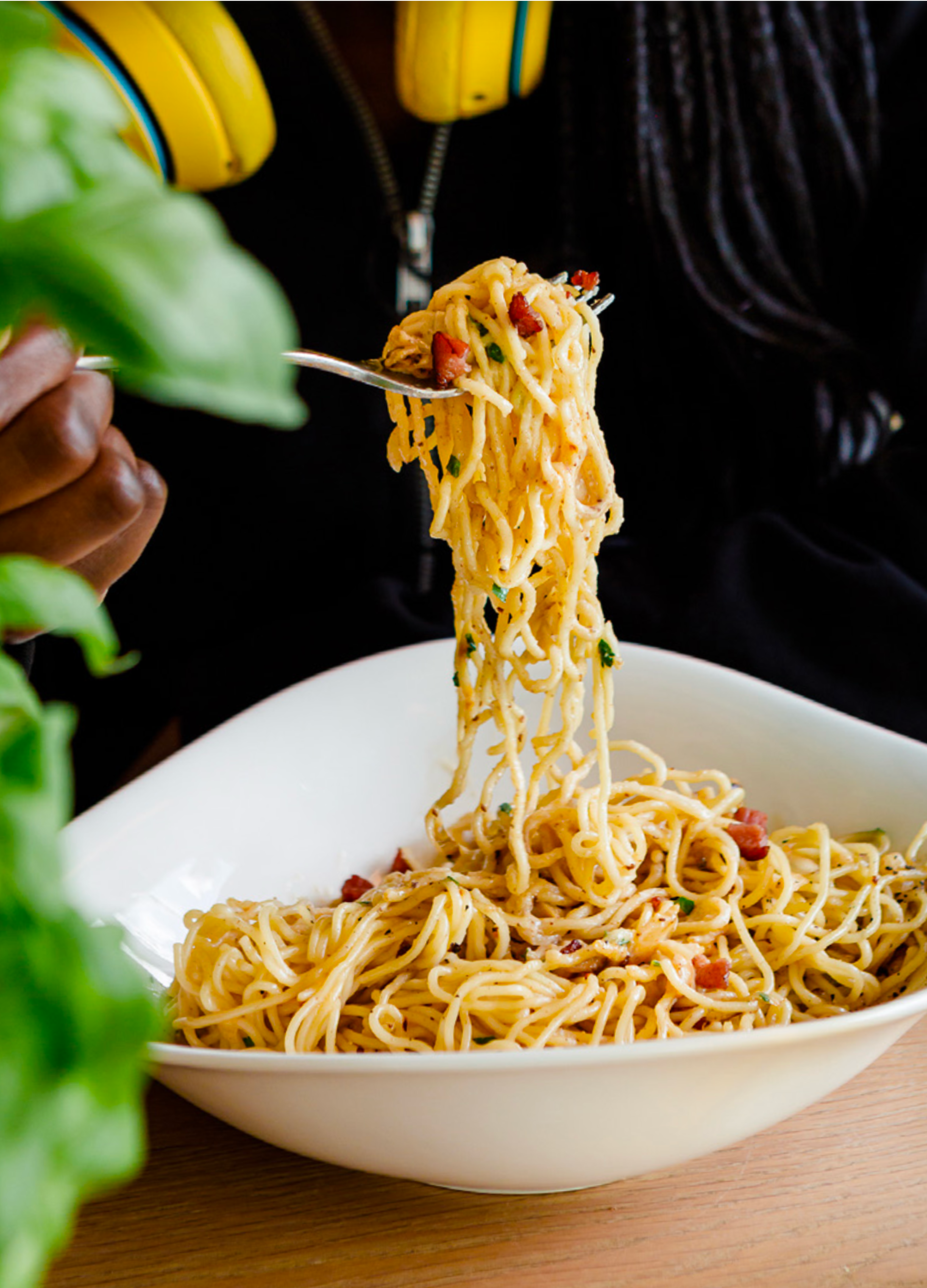 Friends enjoying dinner at Vapiano with fresh basil, pasta dishes, and warm lighting
